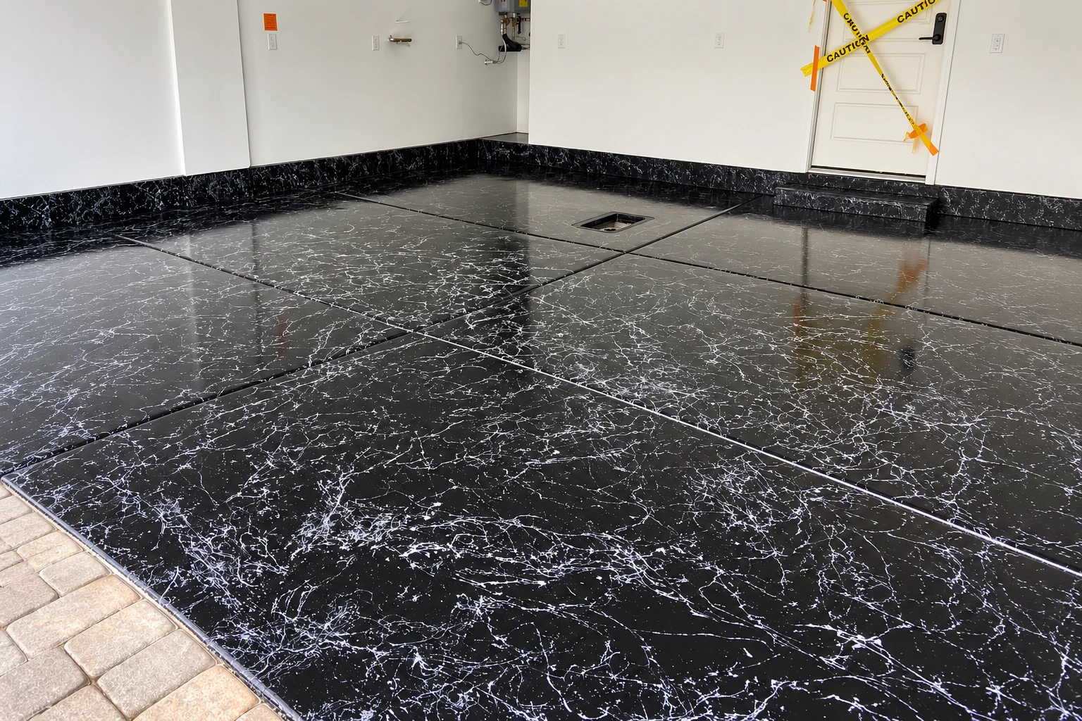Glossy black metallic epoxy floor with fine white veining in a white-walled garage.