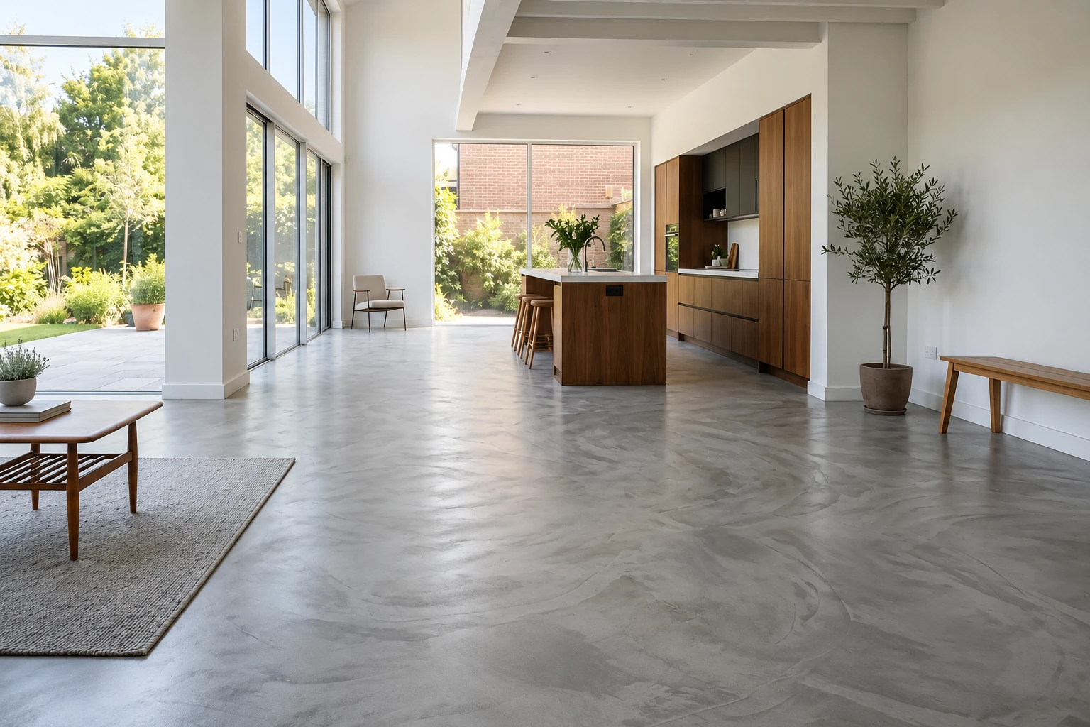 Smooth gray self-leveling concrete overlay in a bright open-plan kitchen and living area.